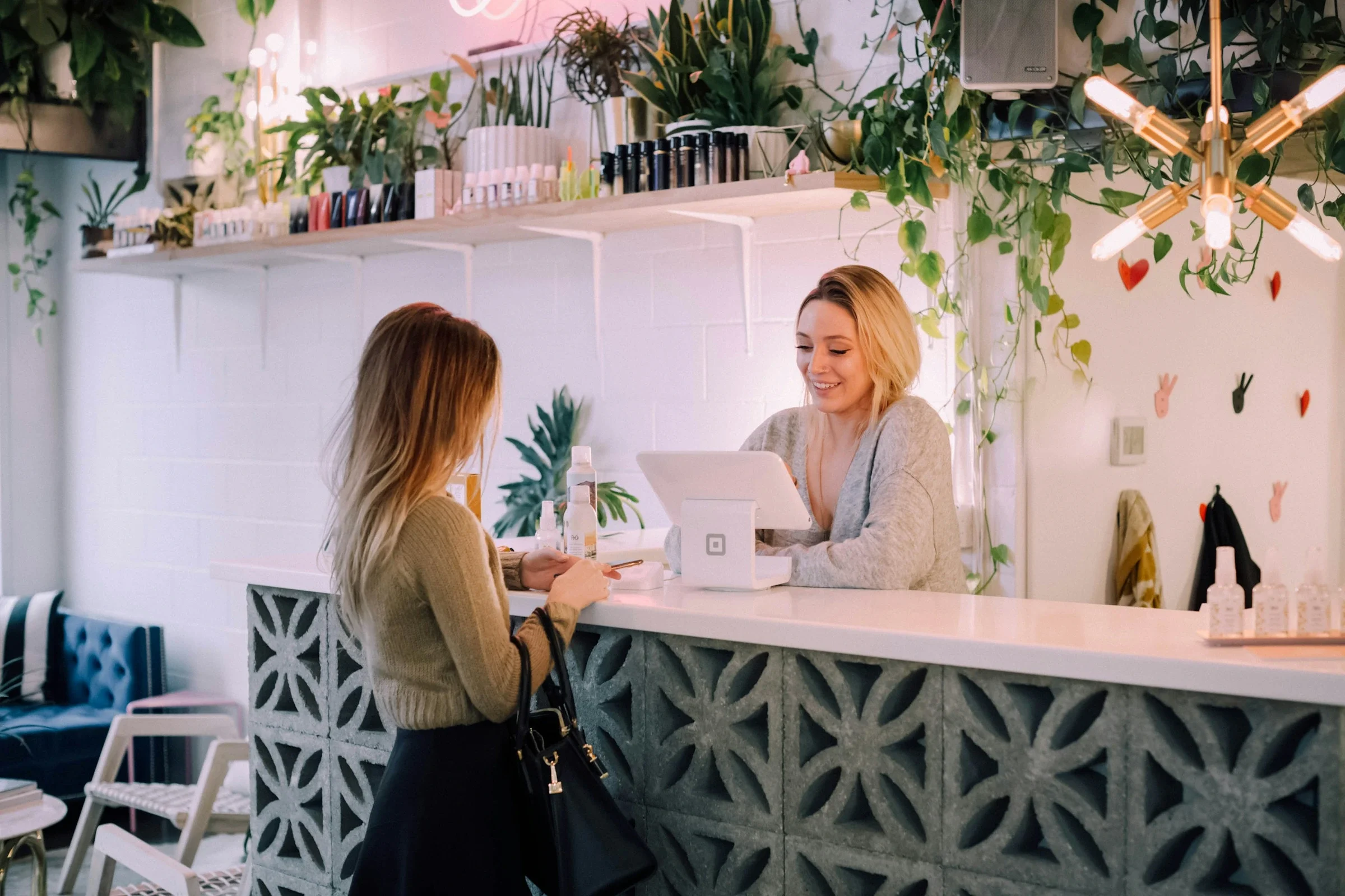 Clienta hablando con la dependienta en el mostrador de una tienda con plantas